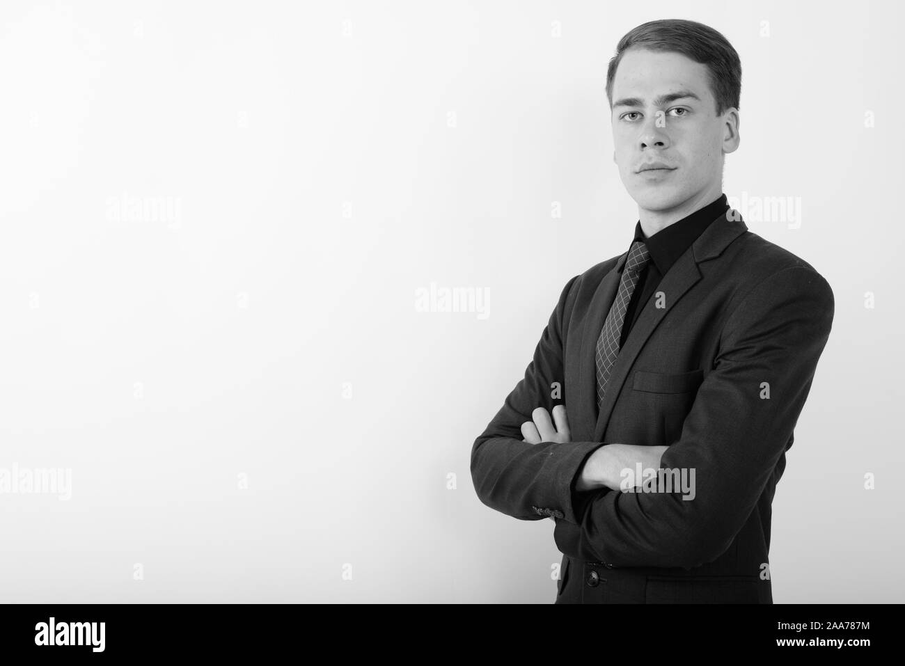 Portrait of young handsome businessman wearing suit in black and white ...