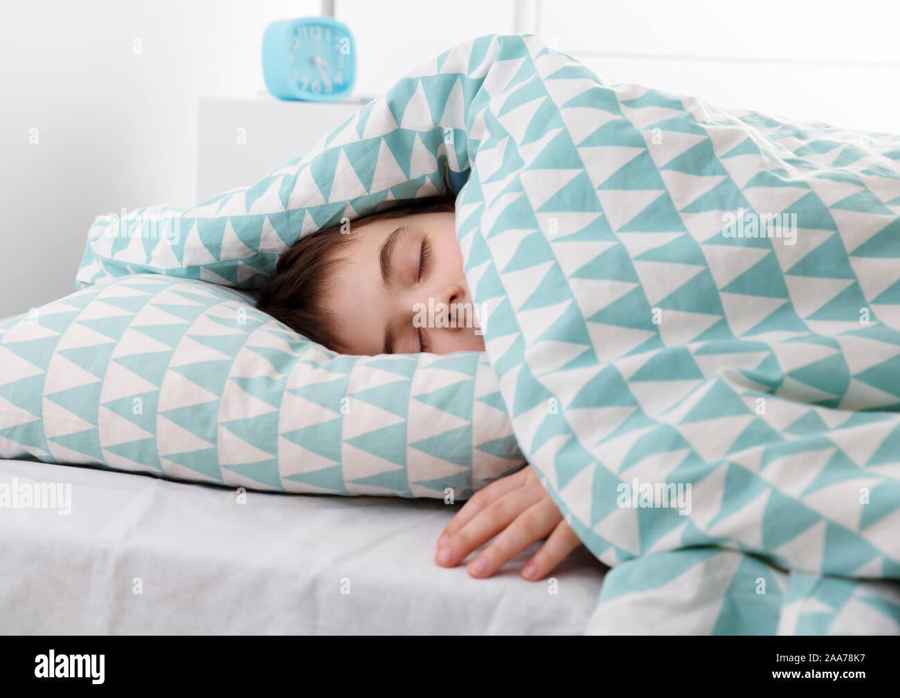 eight years old child sleeping in bed on pillow Stock Photo