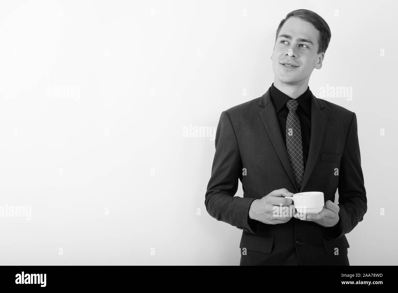 Portrait of young handsome businessman wearing suit in black and white ...