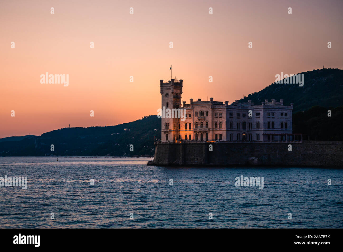 Dramatic view of the tourist spot Castello di Miamare (Castle of Miramare) in Trieste, Italy on the Mediterranean sea coast in europe while sunset. Vi Stock Photo