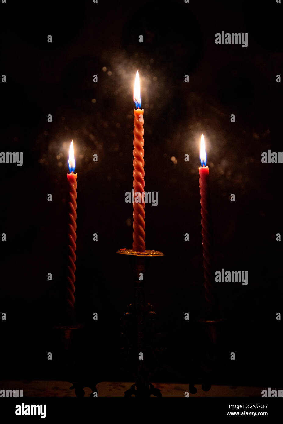 Three red candles burning in the darkness outside the window Stock