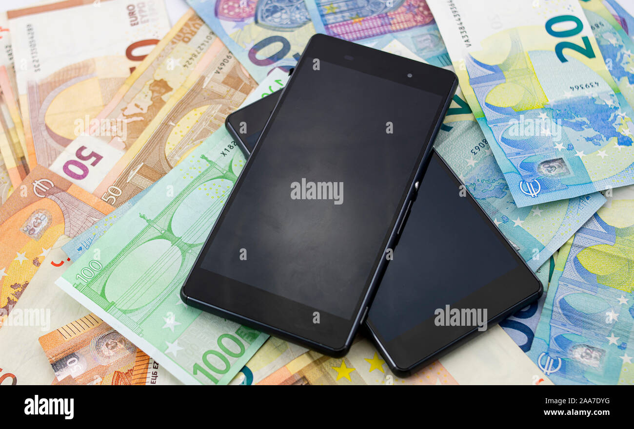 Mobile phones on a background of different euro bills Stock Photo