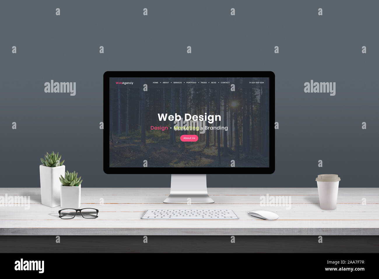 Web design studio concept. Work desk with computer display and modern design web agency page. Stock Photo
