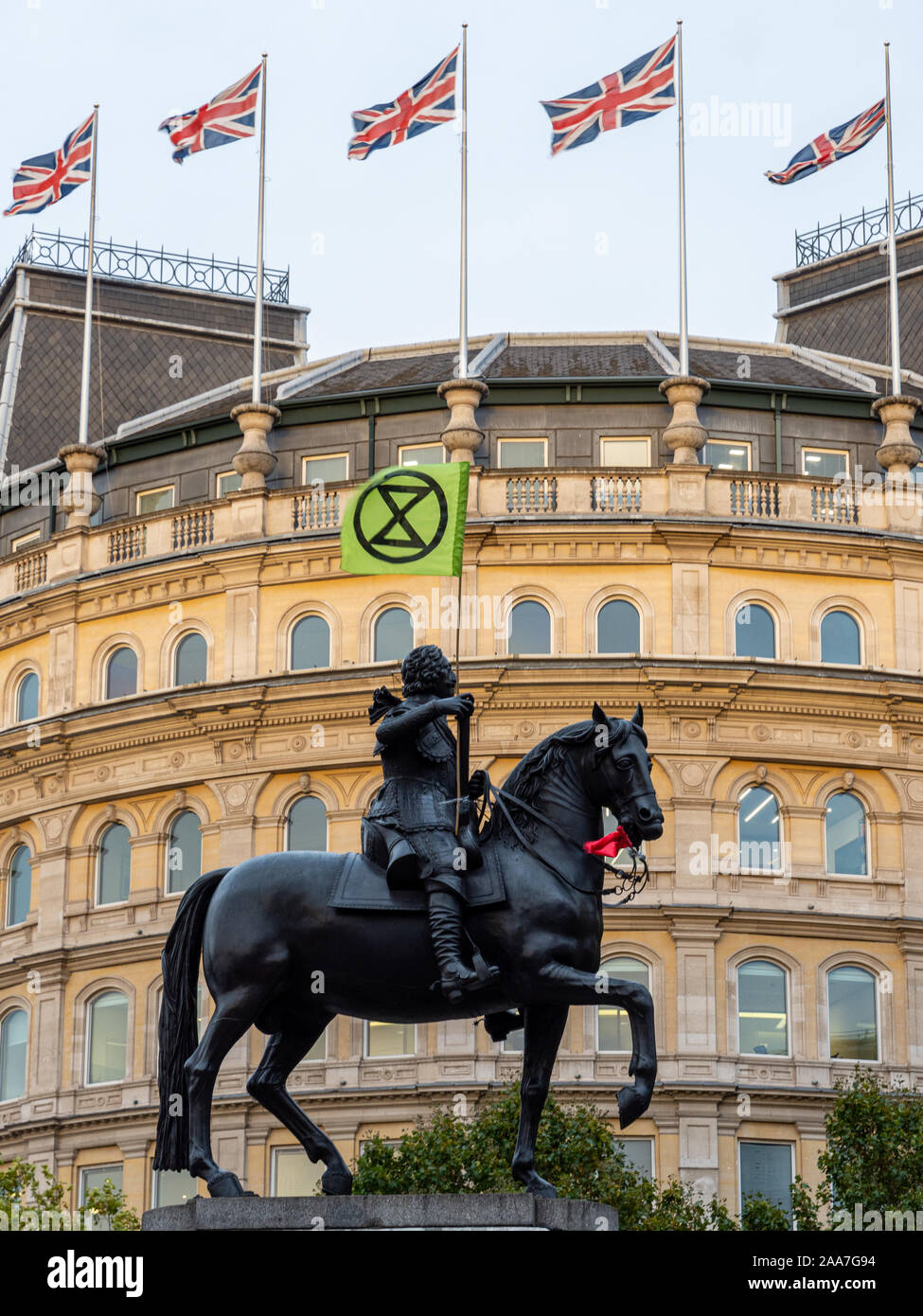 London, England, UK - October 10, 2019: The equestrian statue of Charles I carries an Extinction Rebellion flag during protests in Trafalgar Square in Stock Photo