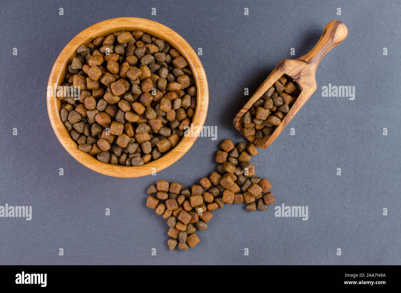 dog food in a bowl and snack like bone on black background, top view Stock Photo