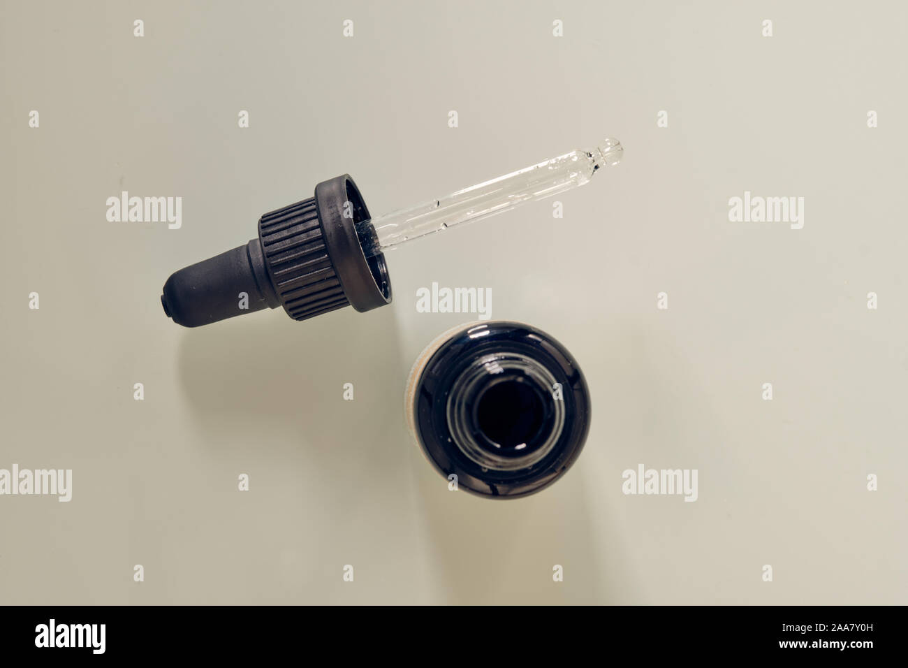 Pipette made of glass with black hold lying on white background. This