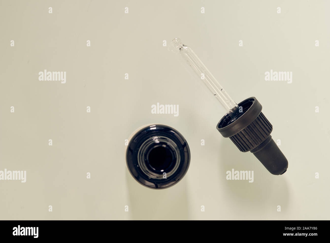Pipette made of glass with black hold lying on white background. This