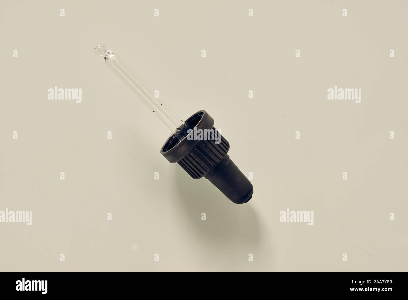 Pipette made of glass with black hold lying on white background. This pipette is made for a vitamin D3 supplement. Stock Photo