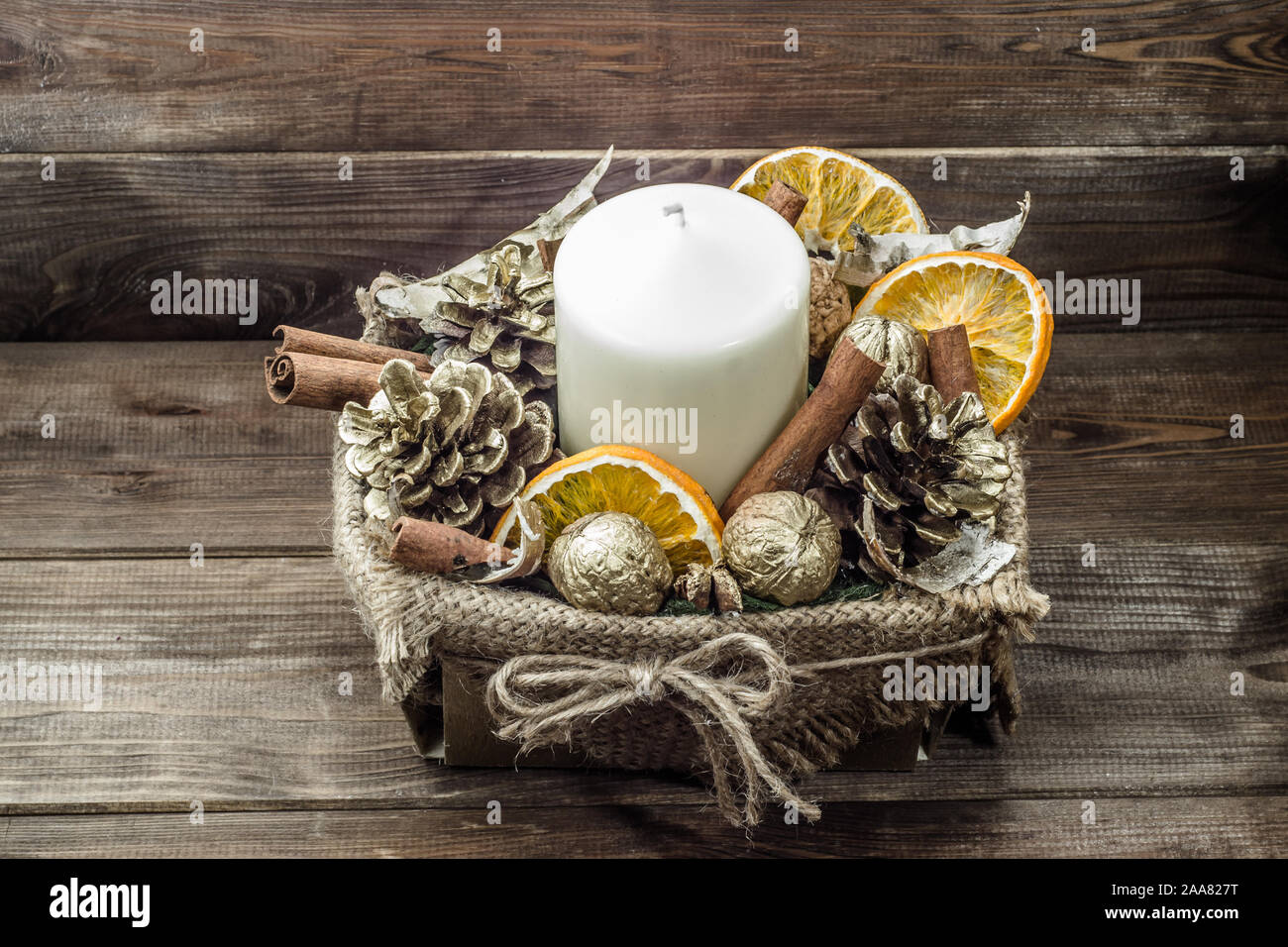 Christmas decoration, candle on wooden table with decorative dried fruits in a box Stock Photo