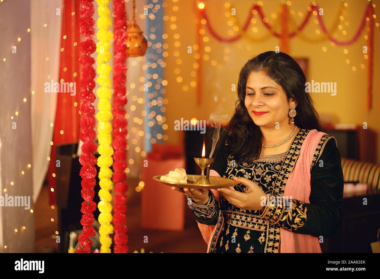Indian woman is Celebrating Diwali. Isolated on decorative background Stock  Photo - Alamy