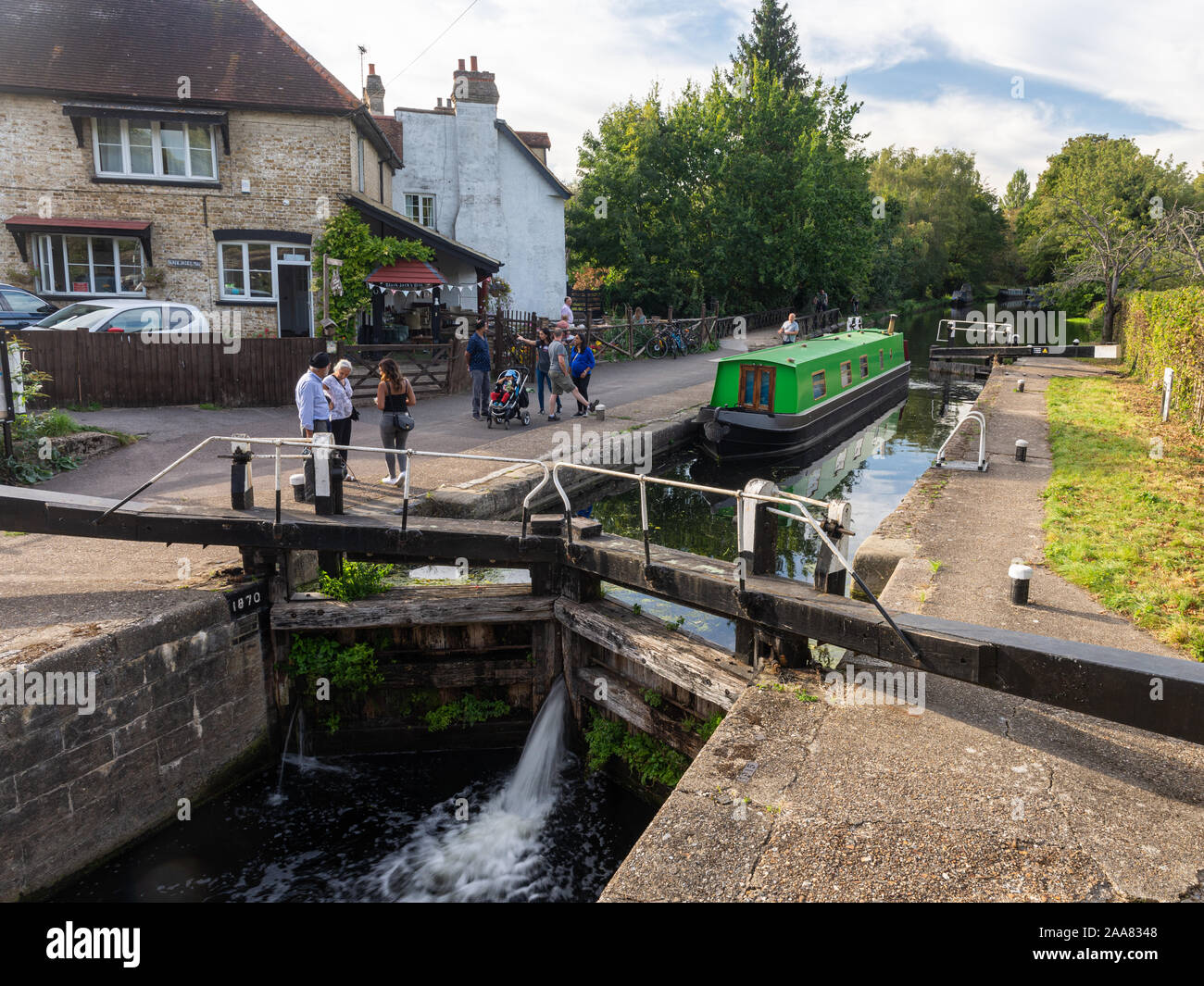 London, England, UK - September 14, 2019: People walk and cycle along the Grand Union Canal towpath while a traditional narrowboat navigates Black Jac Stock Photo