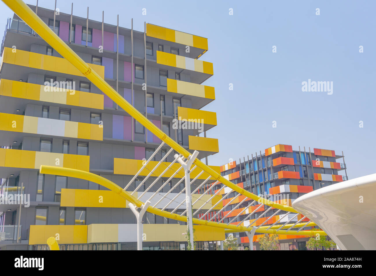 Gold Coast Australia - November 19 2019; Yellow wave-like architectural feature in foreground of modern yellow and orange colored and  designed apartm Stock Photo