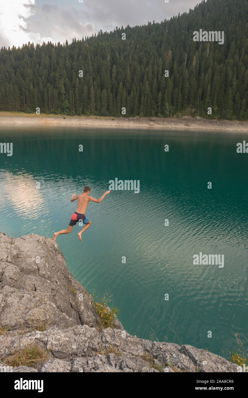 Boy jumping into lake, Durmitor National Park, Montenegro Stock Photo