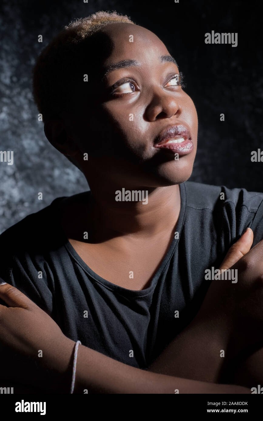 Portrait Of A Beautiful African Girl On A Dark Background A Woman Looks Up Towards A Dramatic Light Source Arms Crossed Stock Photo Alamy Portrait Of A Beautiful African Girl On A Dark Background A Woman Looks Up Towards A Dramatic Light Source Arms Crossed Stock Photo Alamy