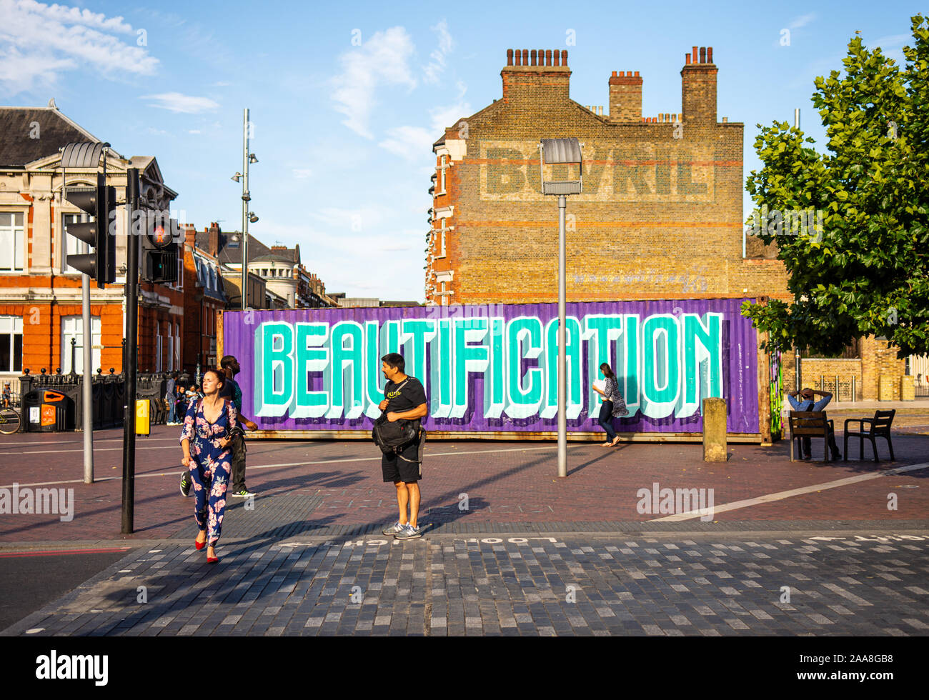 London, England, UK - July 21, 2015: Pedestrians cross a street at Windrush Square in Brixton, a neighbourhood of South London experiencing gentrifica Stock Photo