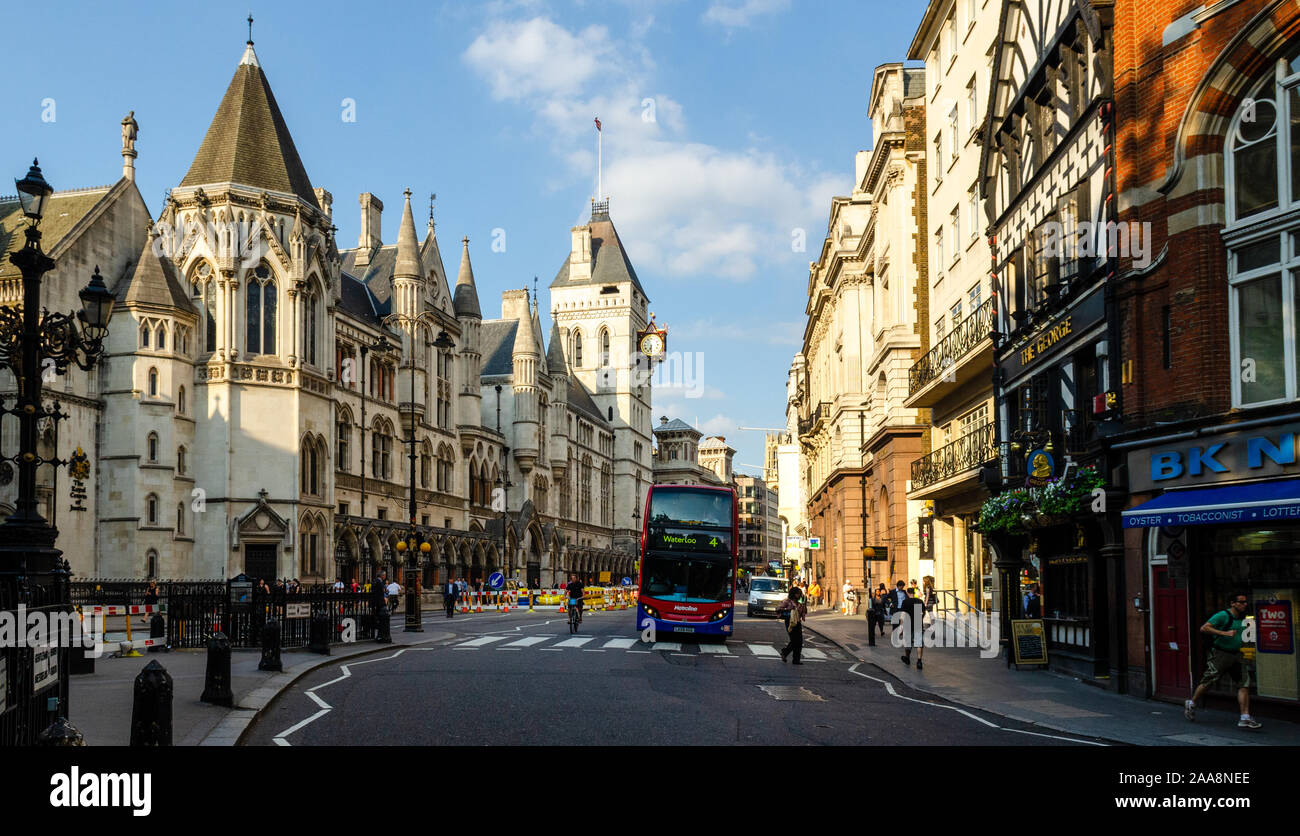 London, England, UK - July 8, 2013: A double-decker bus stops at a pedestrian crossing outside the Royal Courts of Justice on London's Fleet Street. Stock Photo