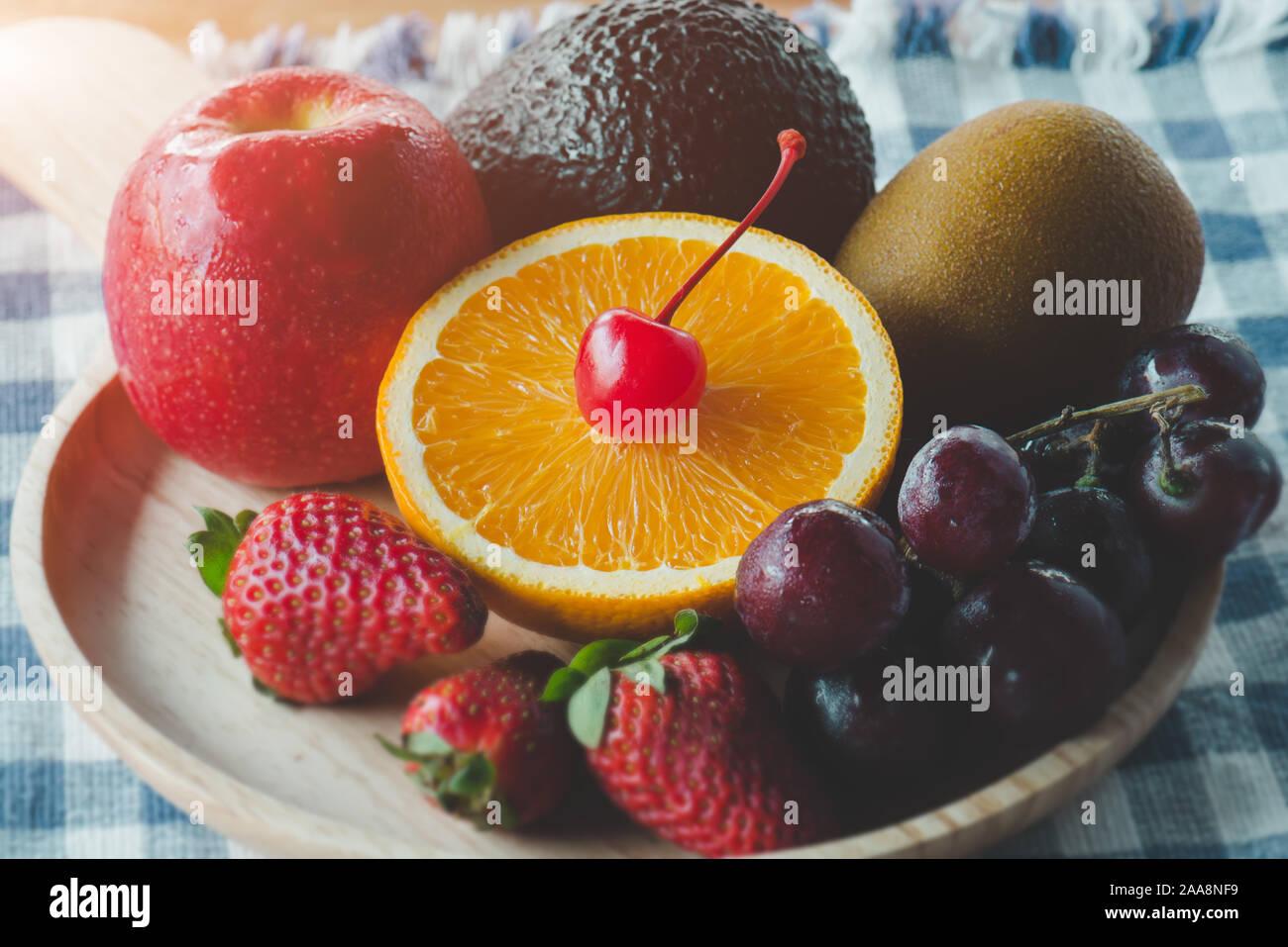 Mix fruits in wooden plate with window lighting.. Stock Photo