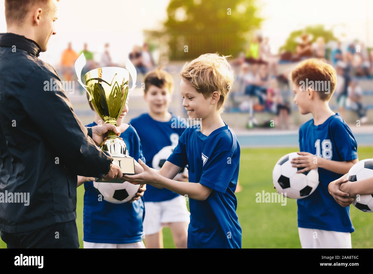 Happy Smiling Young Boys Celebrating Sports Soccer Football Championship. Team Winning Football Tournament for Youth. Sport Background. Young Soccer P Stock Photo