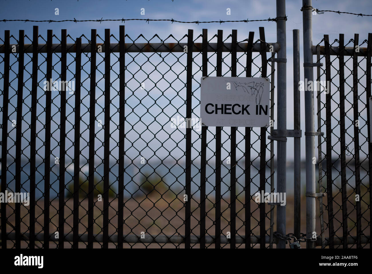 Barbed wire fence with Check In sign Stock Photo