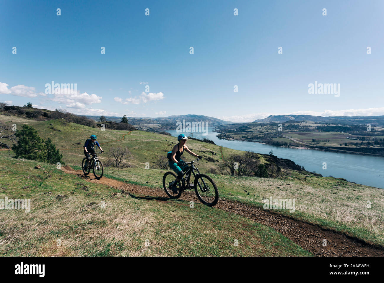 Two young girls bike along a trail overlooking the Columbia River. Stock Photo