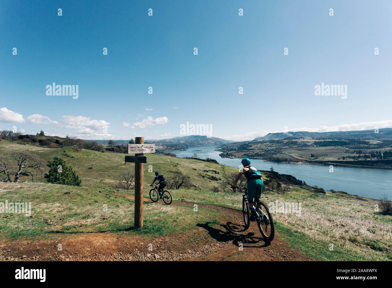 Two young girls bike along a trail overlooking the Columbia River. Stock Photo