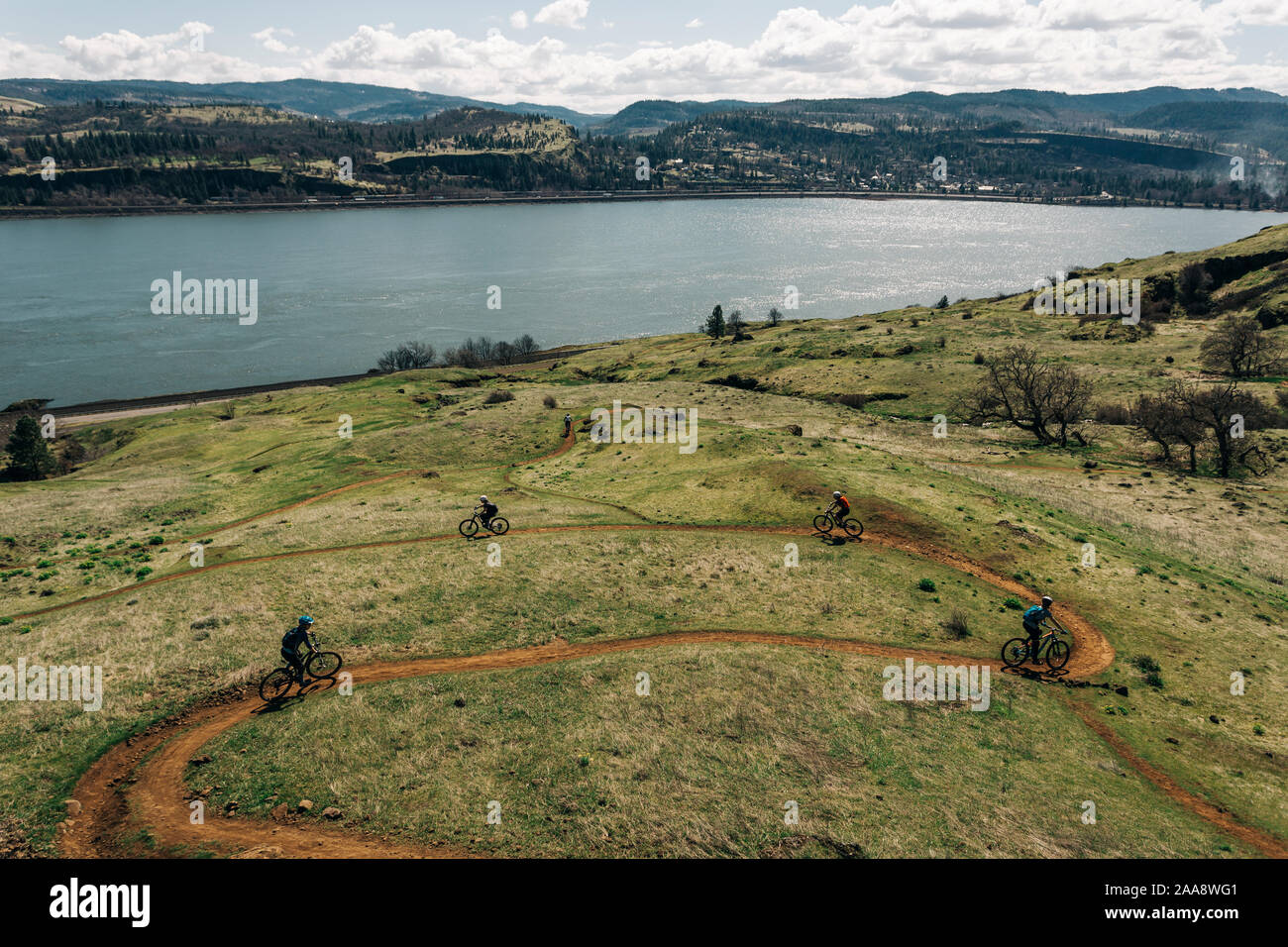 A group of girls bike along a trail overlooking the Columbia River. Stock Photo