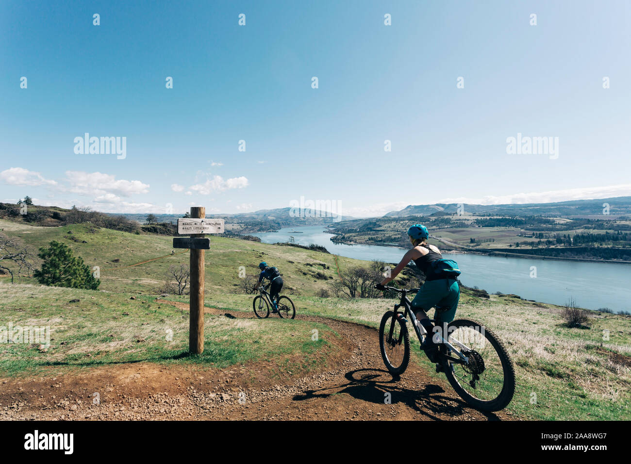 Two young girls bike along a trail overlooking the Columbia River. Stock Photo