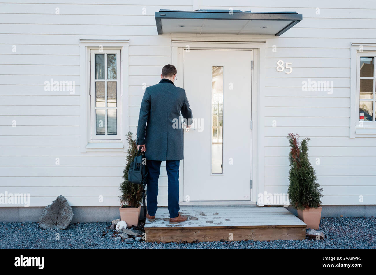 man leaving home for work locking the front door Stock Photo