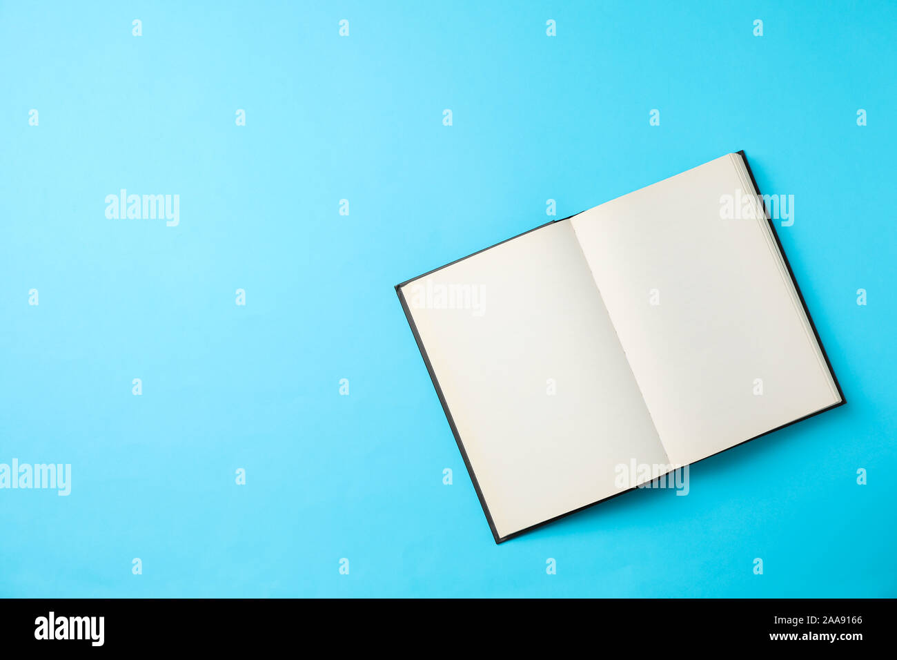 Opened empty book on blue background, space for text Stock Photo