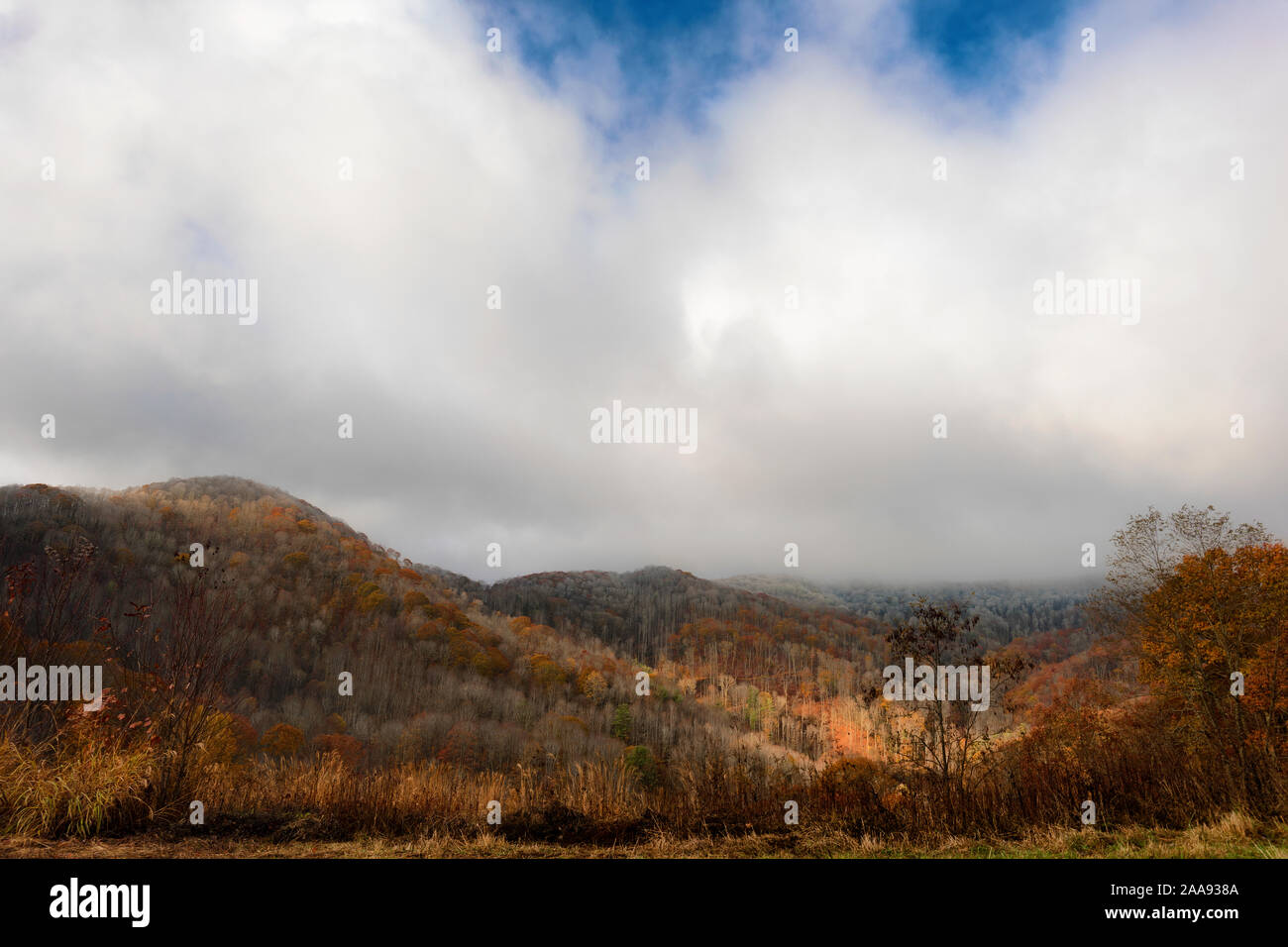 View of stormy weather over section of the Blue Ridge Mountains where a dusting of snow in the higher elevation with warm autumn colors in the lower e Stock Photo