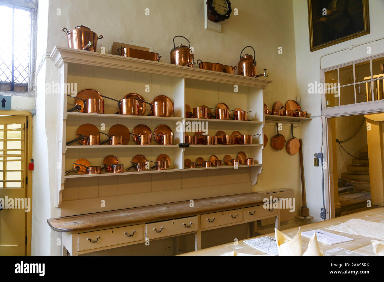 Copper pots and pans on shelves in the kitchen at Hardwick Hall, Derbyshire, England, UK Stock Photo