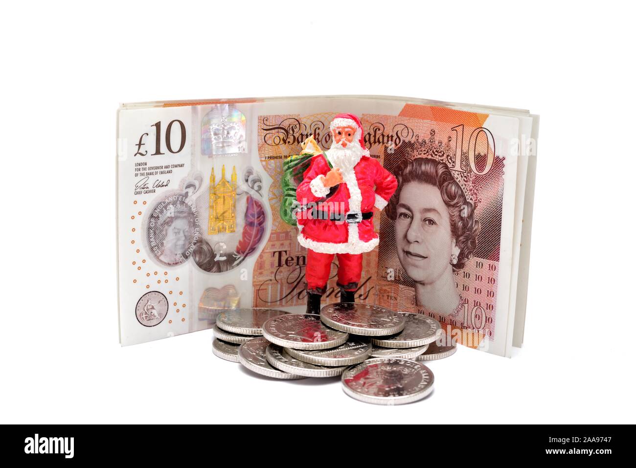 A santa claus figurine standing in front of some new ten pound notes.England UK Stock Photo