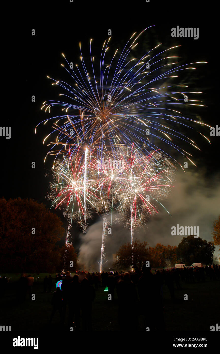 Fireworks display at Harlow Town Park Essex, there are people in the image, but they are silhouetted and unidentifiable Stock Photo