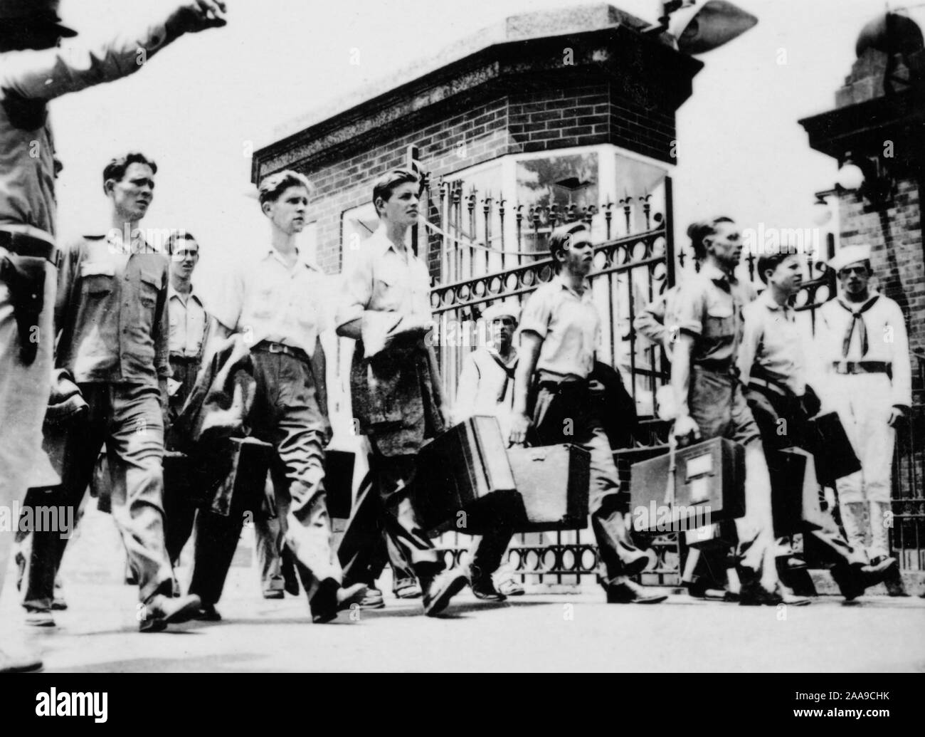 Navy recruits walk into the gates of Great Lakes Naval Training Station, ca. 1941. Stock Photo