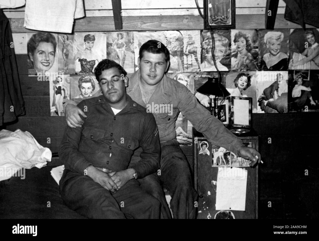 US soldiers in front of some pinup girl photos in their barracks during the Korean War, ca. 1953. Stock Photo