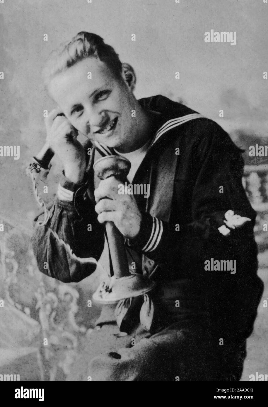A US Navy sailor talks on an early stick telephone, ca. 1930. Stock Photo
