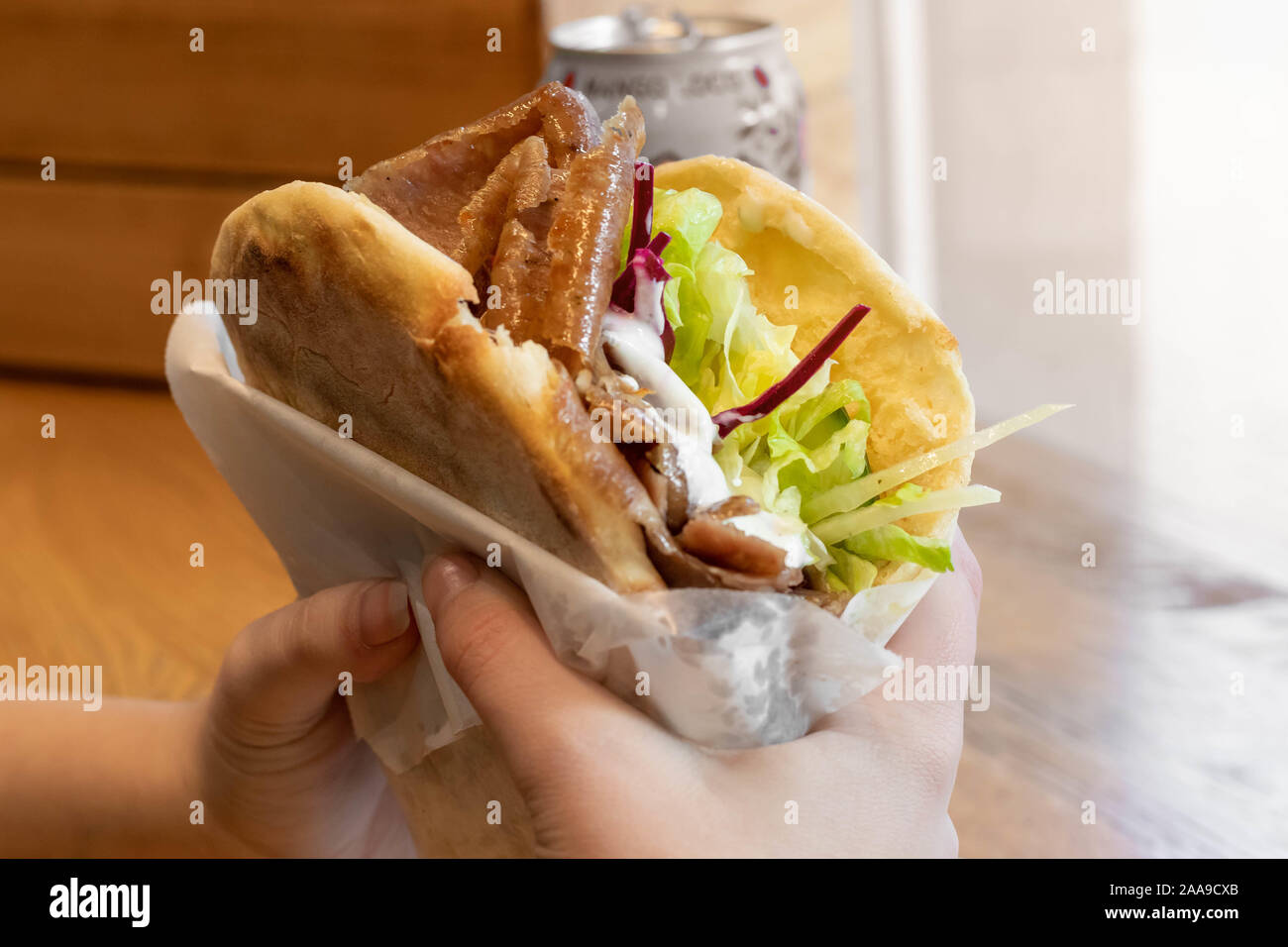 Girl holding a delicious doner in her hands / Girl eating a doner Stock Photo