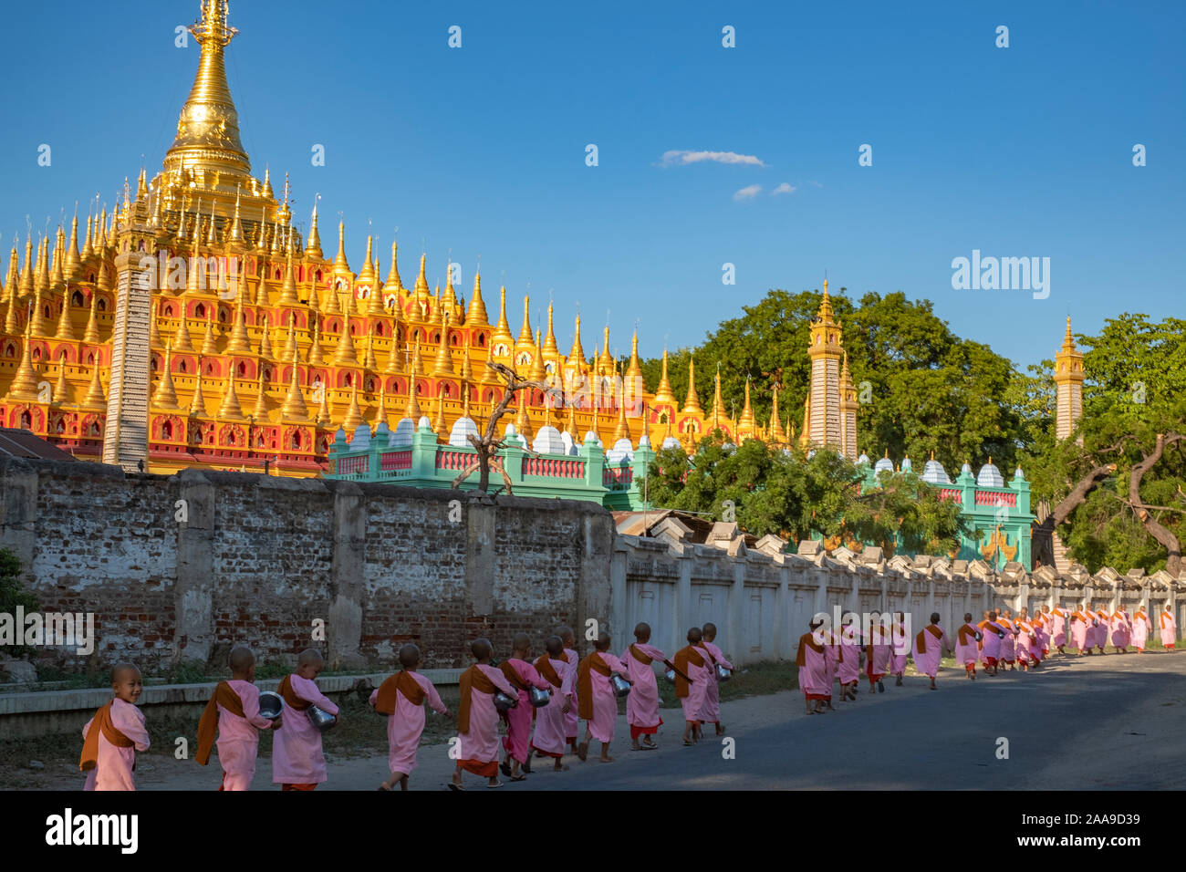 A procession of Buddhist nuns dressed in pink robes head to the Thanboodi (Moe Hnyin Than Boaddai) Temple in Monywa, Myanmar (Burma) for prayers. Stock Photo