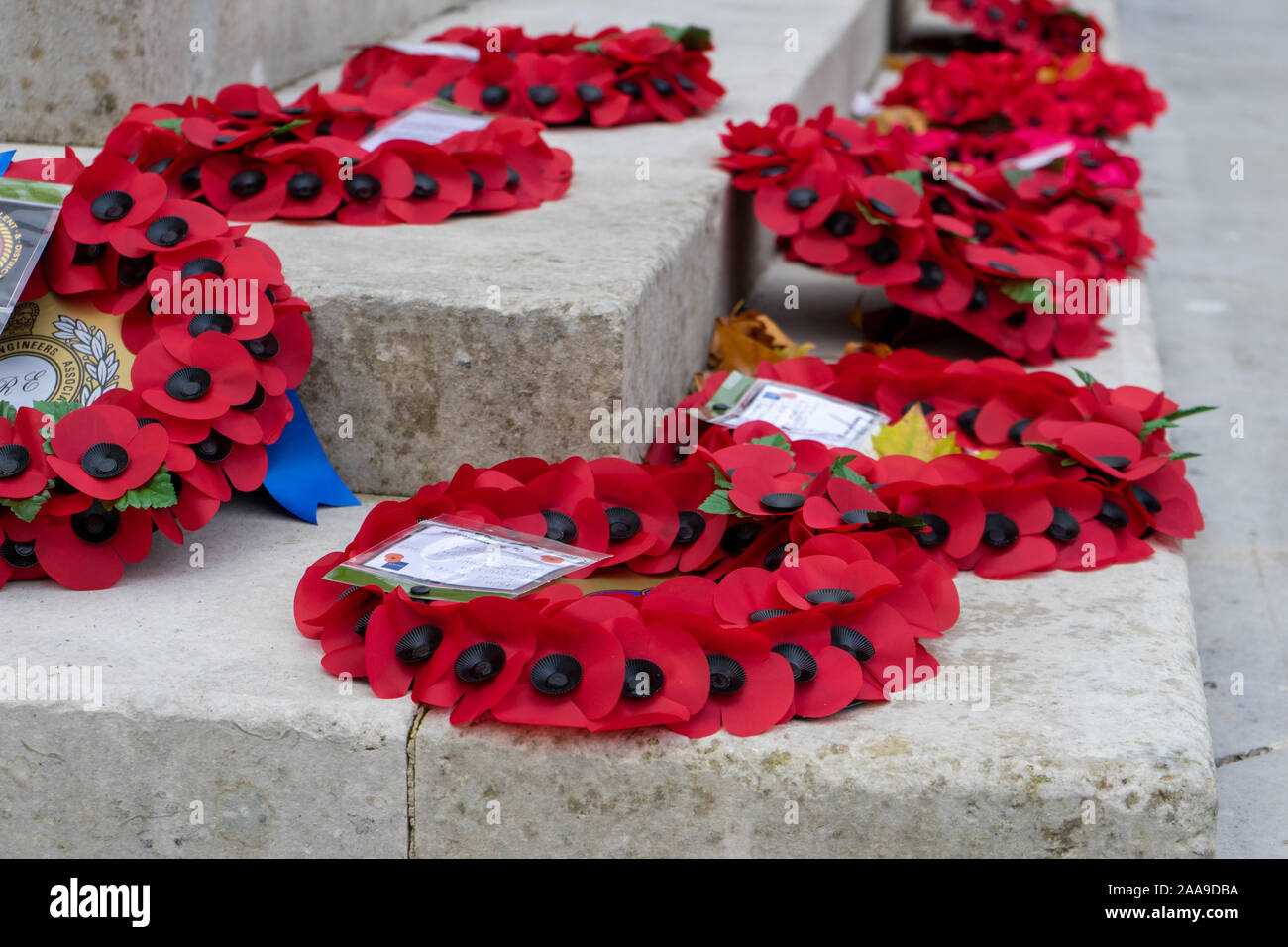 Red poppy wreathes laid around a War memorial on Remembrance Sunday Stock Photo
