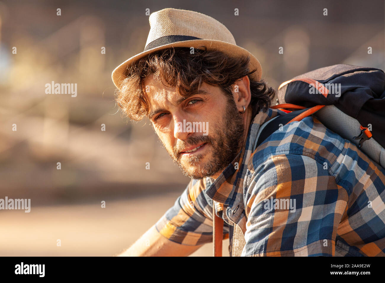 Happy young man tourist wearing shirt and hat smiling at camera at ...
