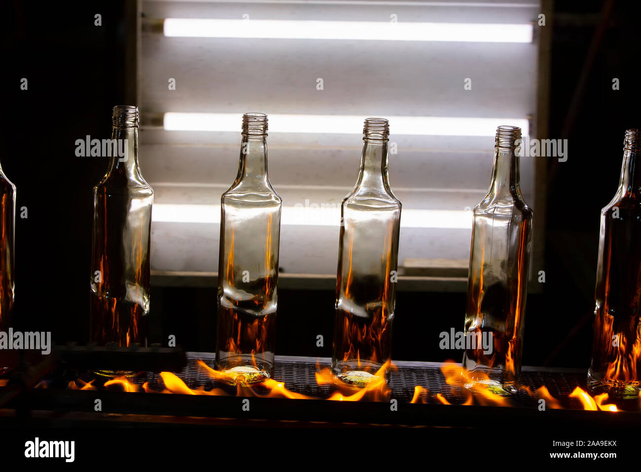 Glass bottles on a conveyor belt on fire. Bottle making process Stock Photo  - Alamy