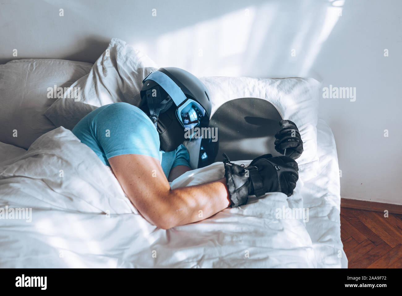 man-in-bed-with-snowboard-ski-googles-and-helmet-2AA9F72.jpg