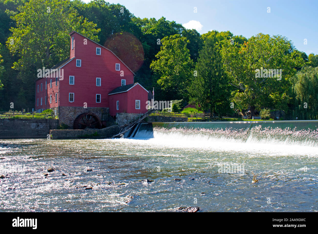 Scenic view of the historic Red Mill in Clinton, New Jersey, on a sunny day, with a waterfall in the foreground Stock Photo