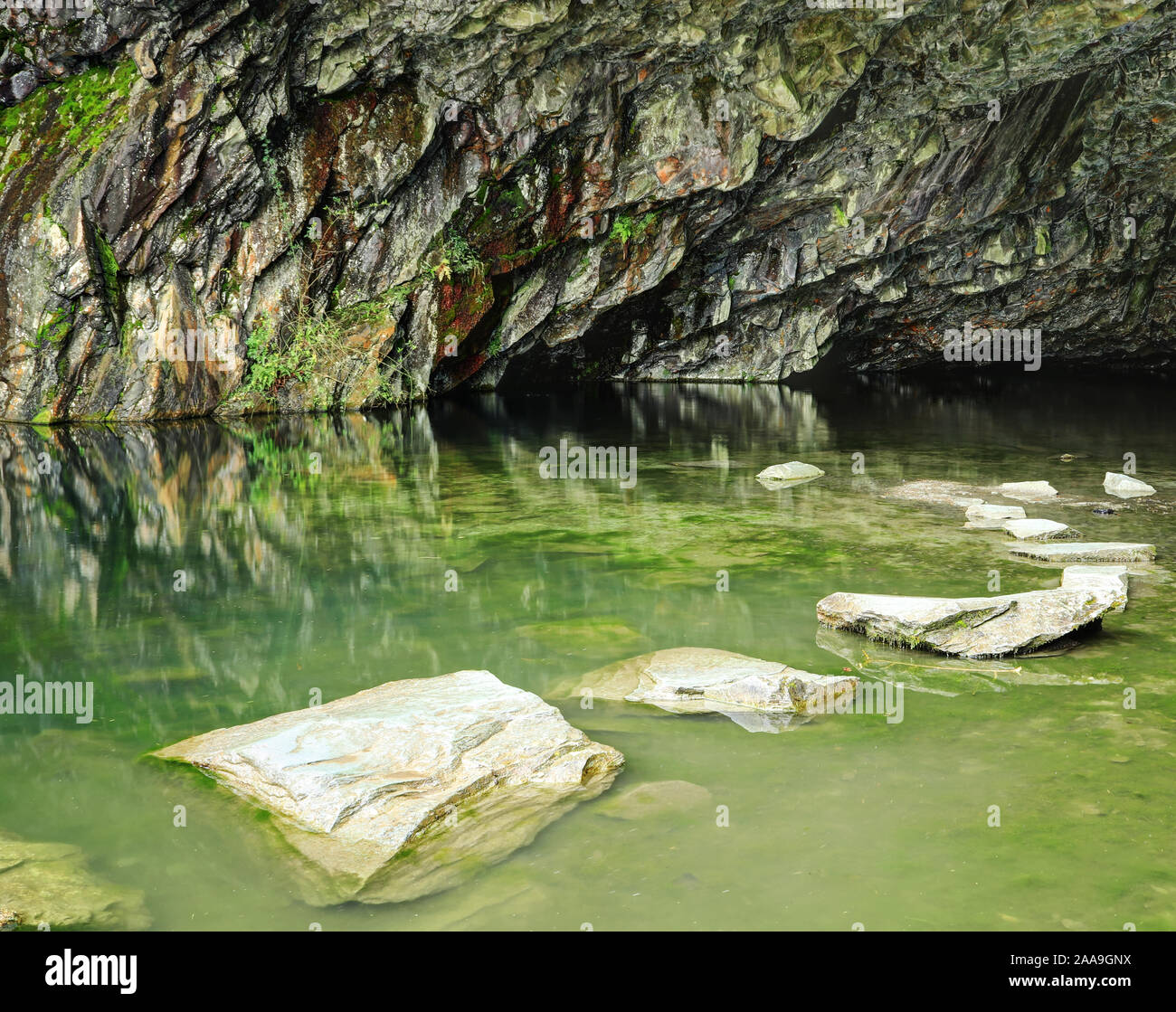 Stepping stones in the colourful cave at Rydal Water, Lake District Stock Photo