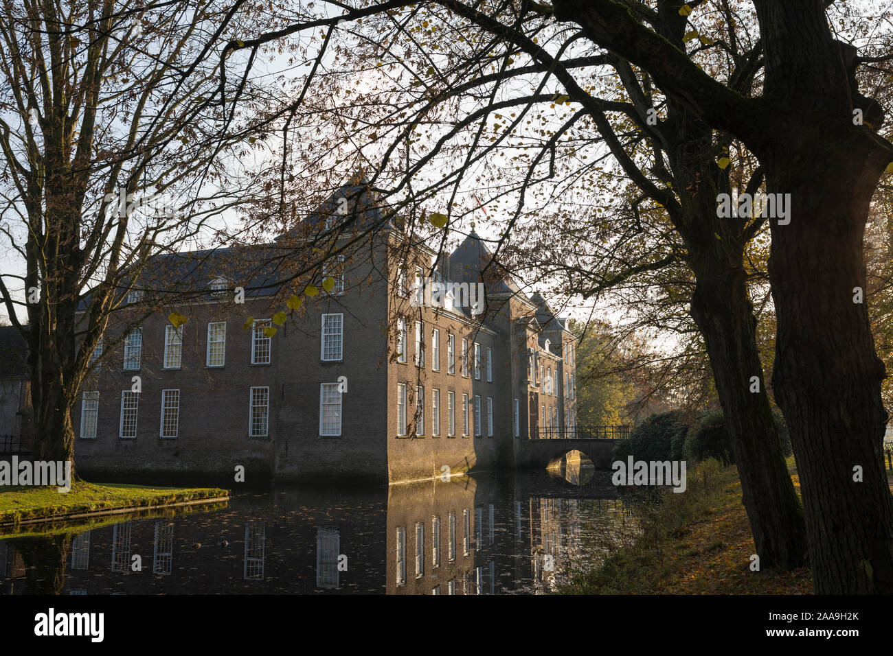 View at the castle of Heeze in autumn, trees and a canal in front, Netherlands Stock Photo