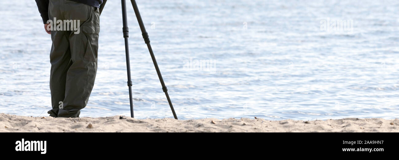 Photographer with tripod at the beach Stock Photo