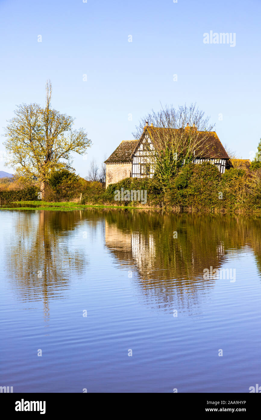 Oddas Chapel seen across floodwater from the River Severn filling fields around the Severn Vale village of Deerhurst, Gloucestershire UK on 18/11/2019 Stock Photo