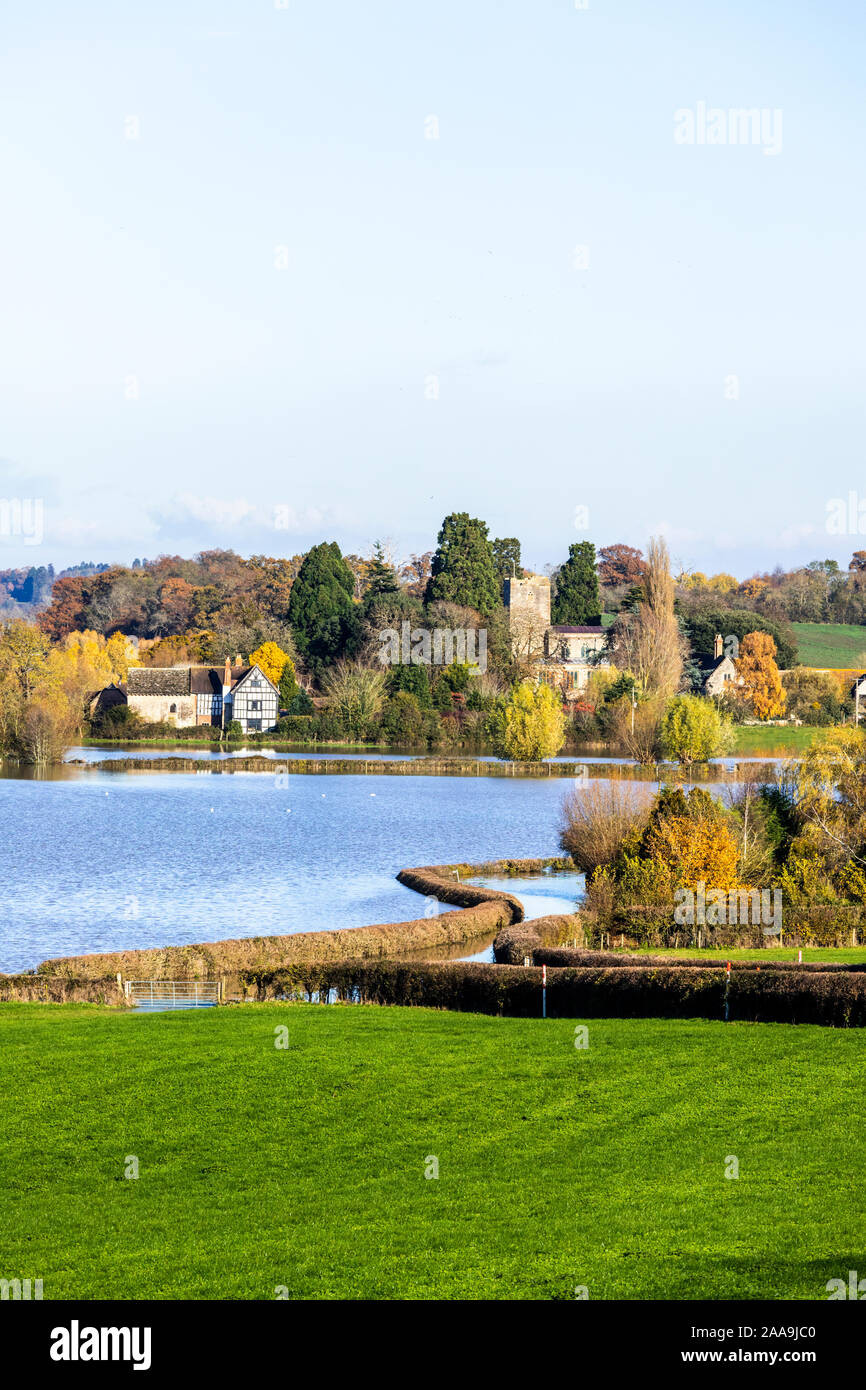 Oddas Chapel & St Marys church seen across River Severn floodwater  filling fields round the Severn Vale village of Deerhurst, Gloucershire 18/11/2019 Stock Photo