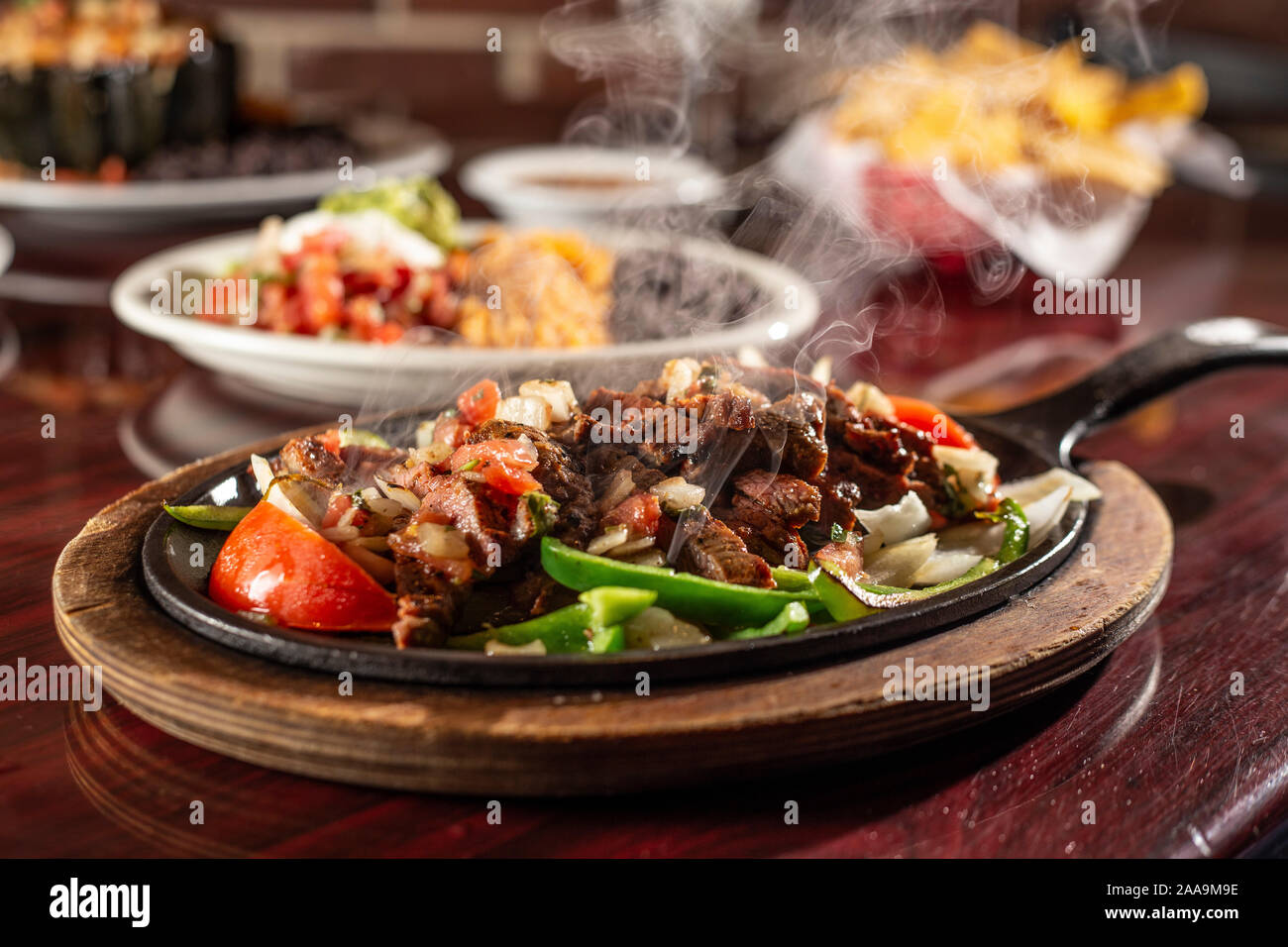 Beef fajitas sizzling on iron skillet Stock Photo Alamy
