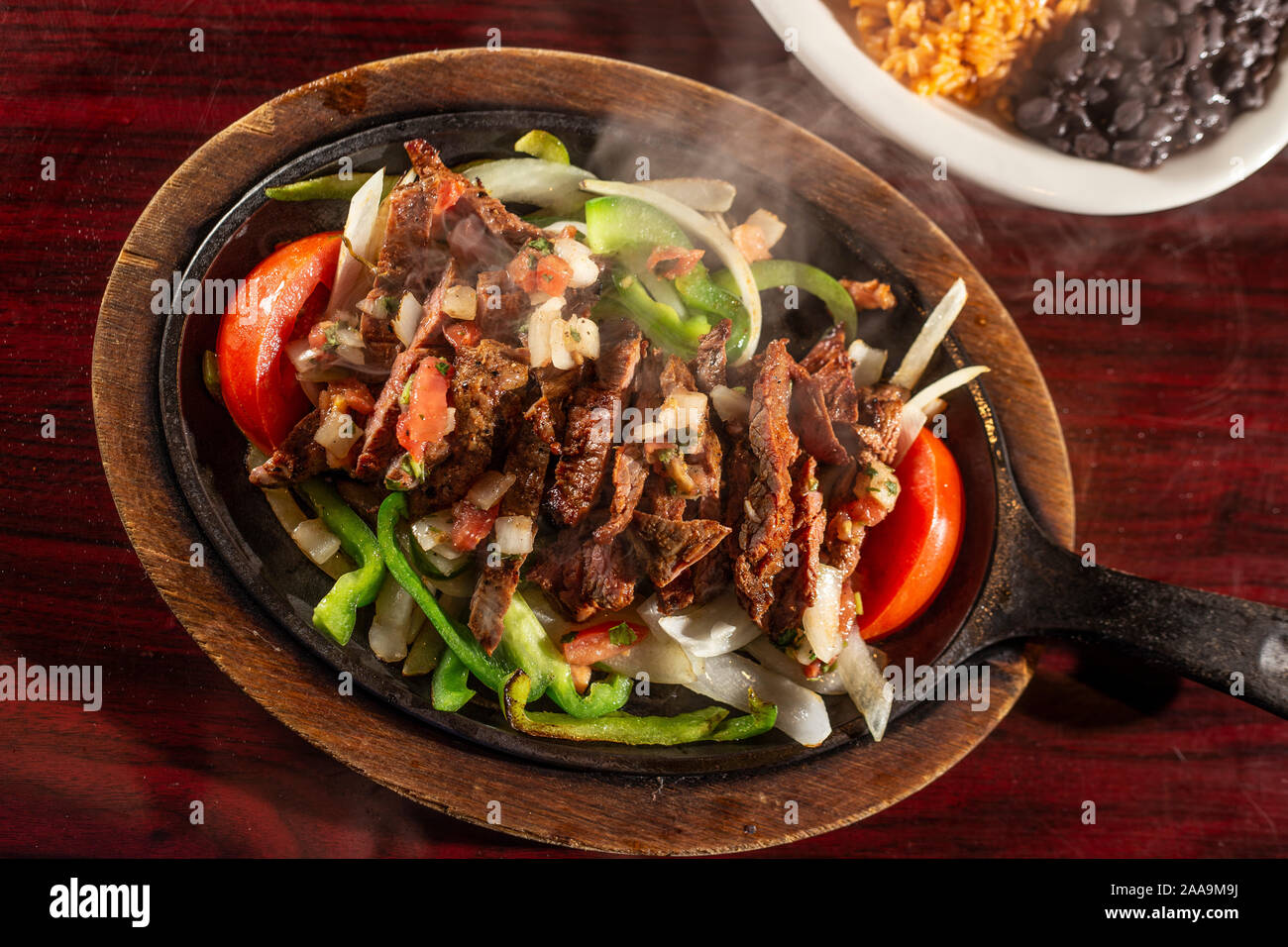 Beef fajitas sizzling on iron skillet Stock Photo Alamy